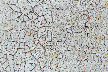 Old cracked white coat of paint background with leaky rustの写真素材
