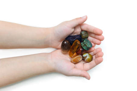 various semiprecious stones in the hands of a child on a white background, isolateの写真素材