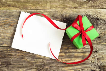 Christmas gift on a wooden table with fir branchesの写真素材