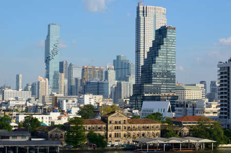 The contrast of old building beside Chao Praya river and modern King Power Mahanakhon and other buildings in Bangkok, Thailand.のeditorial素材