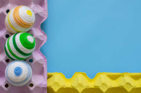 Colorful eggs decorate with knitting wool for Easter day and festival put in purple and yellow egg...