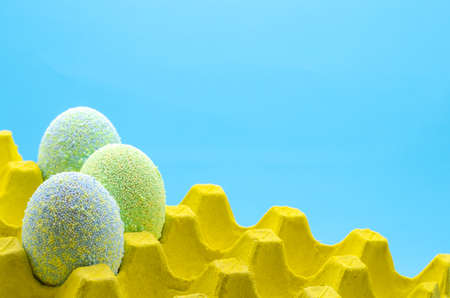 Colorful eggs decorate with Ice cream sprinkle powder for Easter day and festival put in yellow egg...