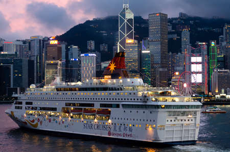 The Star Cruises moving in front of beautiful skyline of Hong Kong city from Tsim Sha Tsui area face to Central area with many high buildings and sea view.のeditorial素材