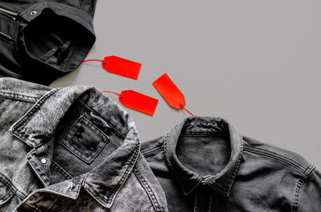 Flat lay of men black clothes with red price tags on gray background for Black Friday shopping sale...