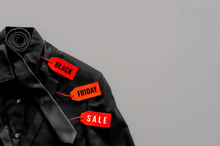 Flat lay of men black color shirt, suit, necktie and red price tags on gray background for Black...