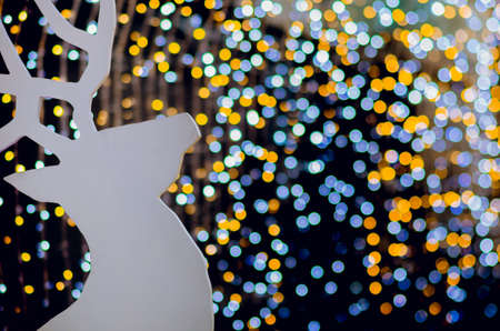 White wooden Reindeer decorates for Christmas Holiday with colorful bokeh lights.