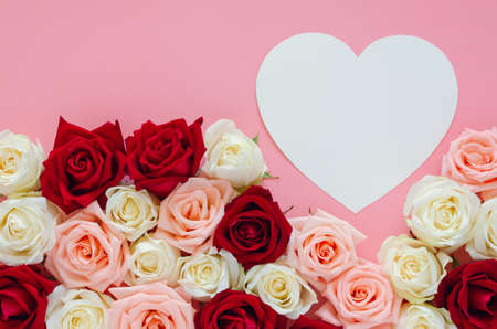 Colorful roses put on pink background with white heart shape for Valentineâs day. Flat lay background concept.の写真素材