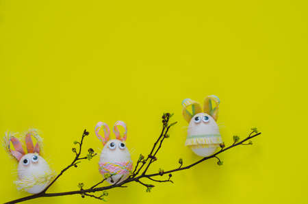 Bunny eggs on tree that have small flowers with yellow background for Easter festival concept.