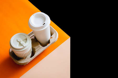 The recycle cups of coffee in reuse paper tray put on colorful paper and dark background for World...