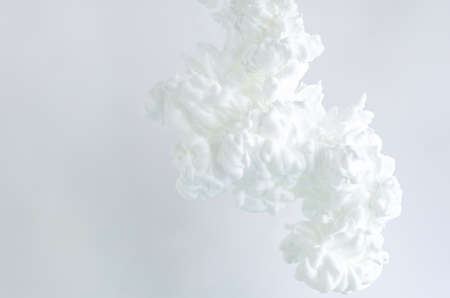Blurred and focus white poster color dissolving in water for abstract and backgorund concept.