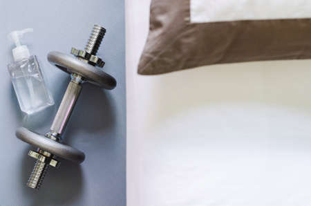 Pumping bottle of alcohol gel for cleaning hand after use dumbbell when doing exercise in bedroom...