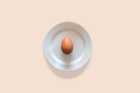 Egg puts on white plate for minimal food concept.の写真素材