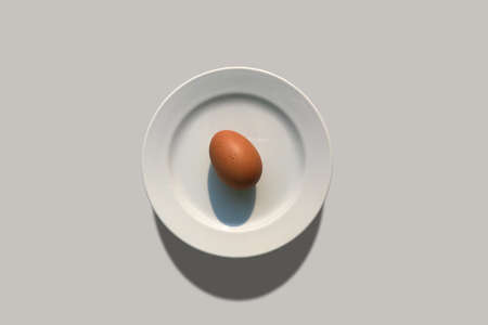 Egg puts on white plate for minimal food concept.の写真素材