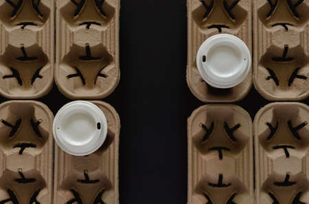 Two coffee tumblers on recycle paper trays put separate to each other with the gap. New normal and...