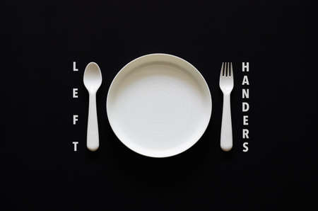 Spoon put on left side of the dish on black background for International left handers day conceptの写真素材