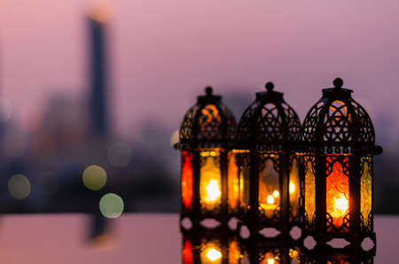 Lanterns with dusk sky and city bokeh light background for the Muslim feast of the holy month of Ramadan Kareem.の写真素材