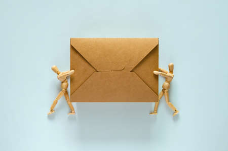 Two wooden models holding disposable, compostable paper food box for world environment day concept.の写真素材