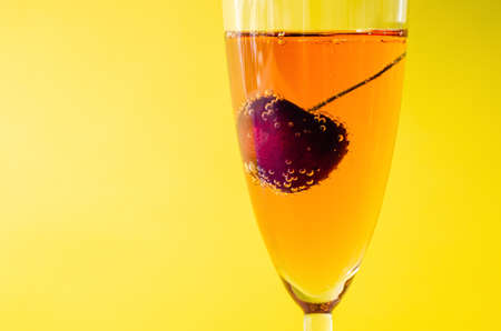 A glass of sparkling rose wine with cherry fruit inside served as a welcome drink. Summer drink concept.の写真素材