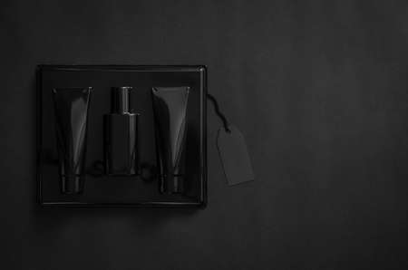 A black box of perfume with blank black price tag on black background. Black Friday concept.の写真素材