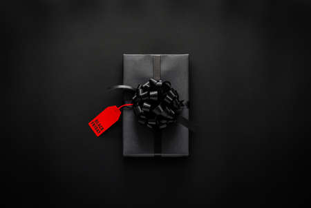 Black gift box that have price tag with word on black background. Black friday concept.の写真素材