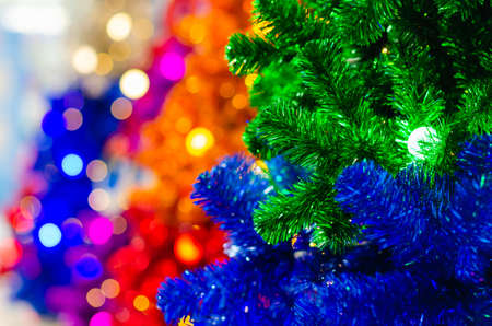Selective focus on green Christmas tree with light bulb and blurred focus of colorful Christmas trees.の写真素材