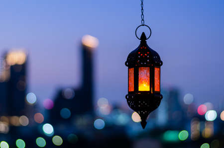 Hanging lantern with night sky and city bokeh light background for the Muslim feast of the holy month of Ramadan Kareem.の写真素材