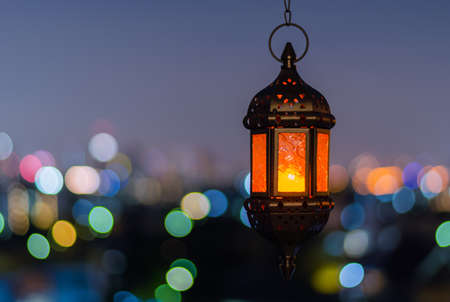 Hanging lantern with night sky and city bokeh light background for the Muslim feast of the holy month of Ramadan Kareem.の写真素材