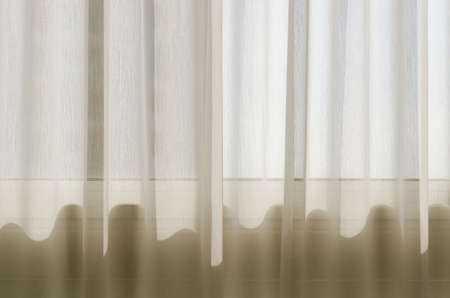 White curtain in bedroom with waving shadow from sunlight in the morning.の写真素材