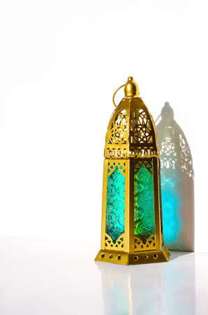 Golden lantern with shadow from sun light on white background.の写真素材