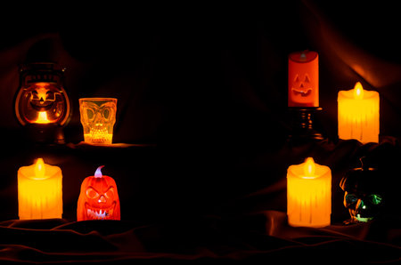 Selective focus on the front orange color Jack o lantern with blurred focus candles for Scary halloween background concept.の写真素材