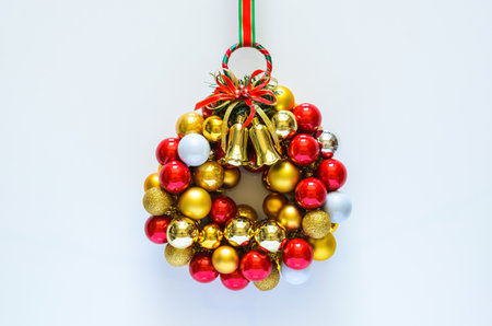 Colorful Christmas wreath made from baubles ornament on white background. Minimal holiday concept.の写真素材