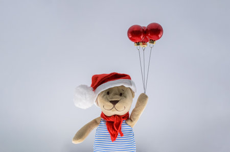 Teddy bear santa claus holding red baubles ornament set as balloon on white background. Minimal holiday concept.の写真素材