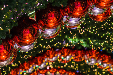 Red bauble and other ornament hanging on Christmas tree with bokeh light background.の写真素材