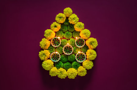 Clay diya lamps lit to celebrate for Diwali festival with colorful flowers set as flame shape on...