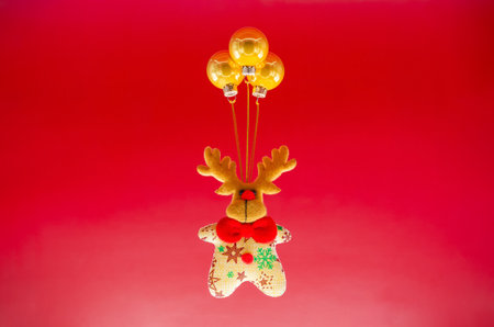 Christmas ornament with deer and gold baubles ornament set as balloon on red background. Minimal holiday concept.の写真素材