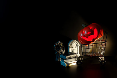 Halloween background with Jack o lantern that have light inside on shopping cart with small decorations on black background. Minimal concept.の写真素材