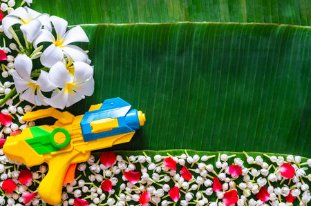 Water gun with flowers on banana leaves background for Thailand Songkran festival concept,の写真素材
