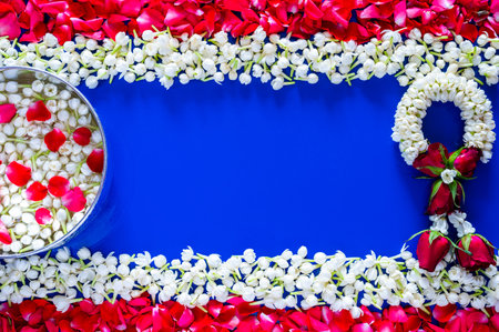 Flowers in water bowl for blessing with jasmine garland on blue background set as Thailand flag with...