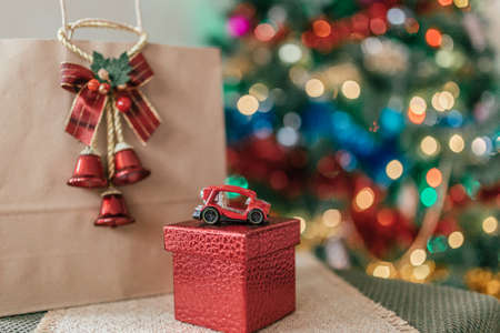 craft package with a gift on the background of a Christmas treeの写真素材