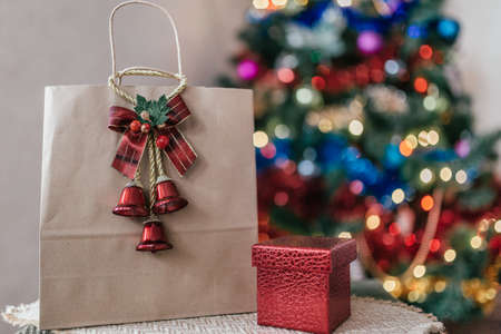 craft package with a gift on the background of a Christmas treeの写真素材