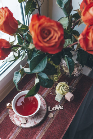 still life valentine's day with red flowers on the windowの写真素材