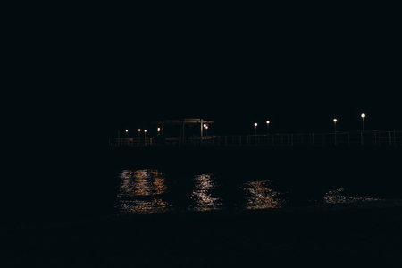View of the night pier from the seashoreの写真素材