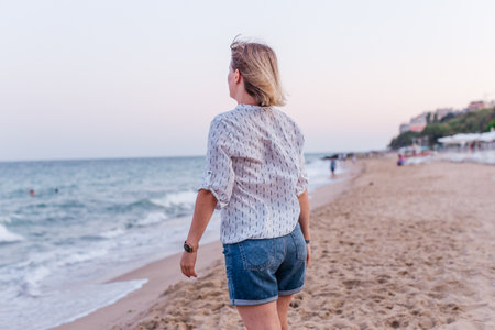 Portrait of a girl walking along the beach of the sea coastの写真素材