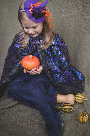 Portrait of a girl in carnival clothes for Halloween with pumpkinの写真素材
