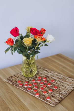 Colorful bouquet of flowers on the table and sweets in the shape of a heart. Composition for Valentine's Day February 14th.の写真素材