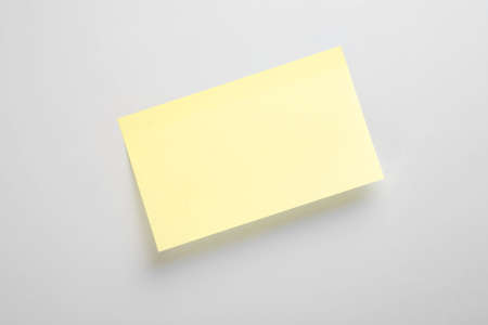 A wide yellow sticky note on a gray backgorundの写真素材