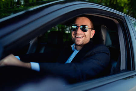 businessman in car smiling