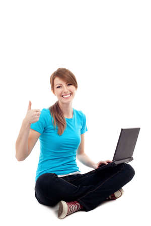 Female student sitting with laptop thumbs up. Isolated on white backgroundの写真素材