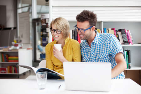 Students sitting at the table in libraryの写真素材