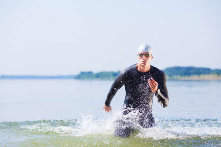 Triathlete running out of the water on triathlon race.の写真素材